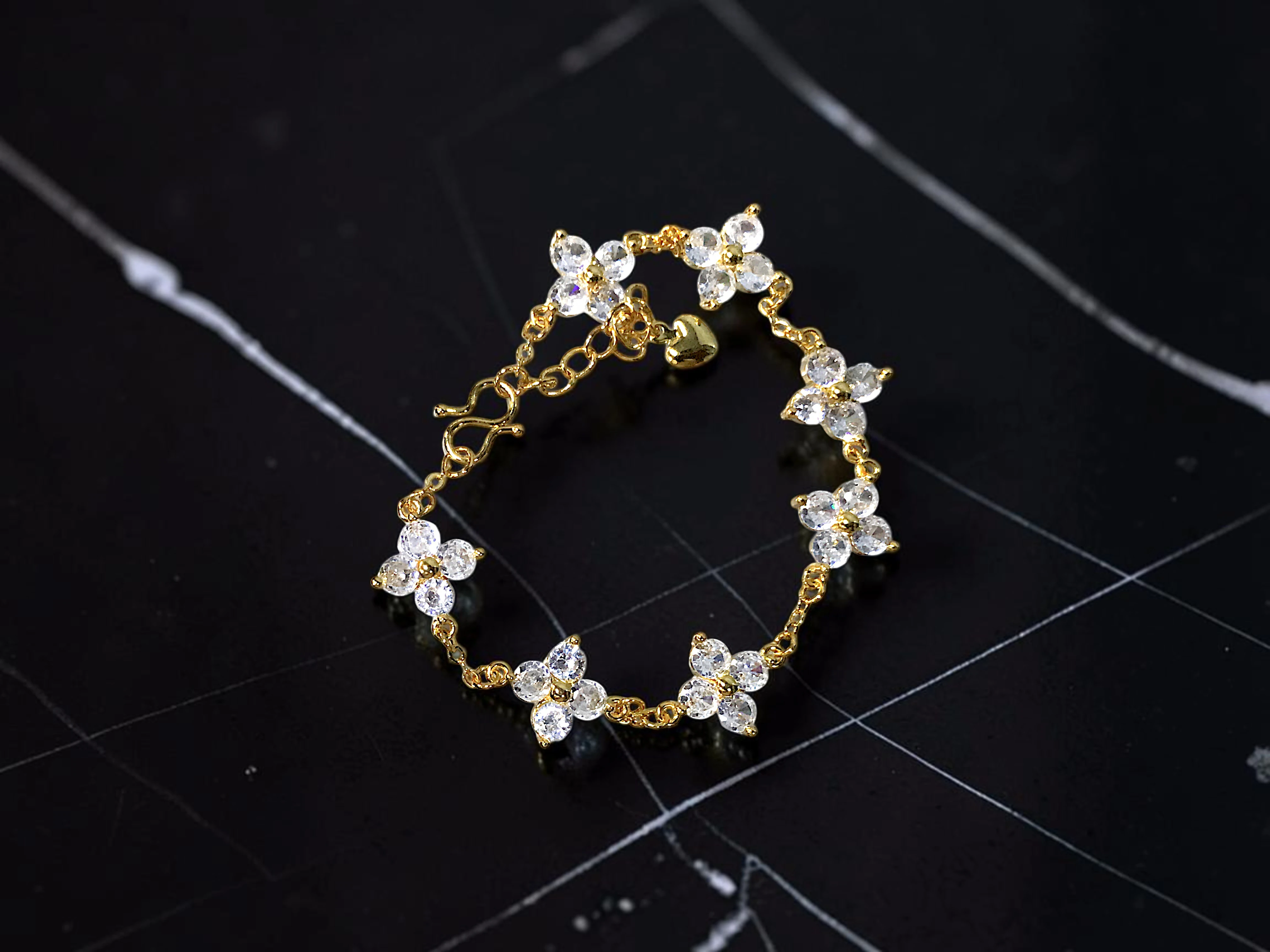 PULSERA DELGADA CON TRÉBOLES, JOYERÍA FINA EN CHAPA DE ORO CON INCRUSTACIONES DE ZIRCONIAS.