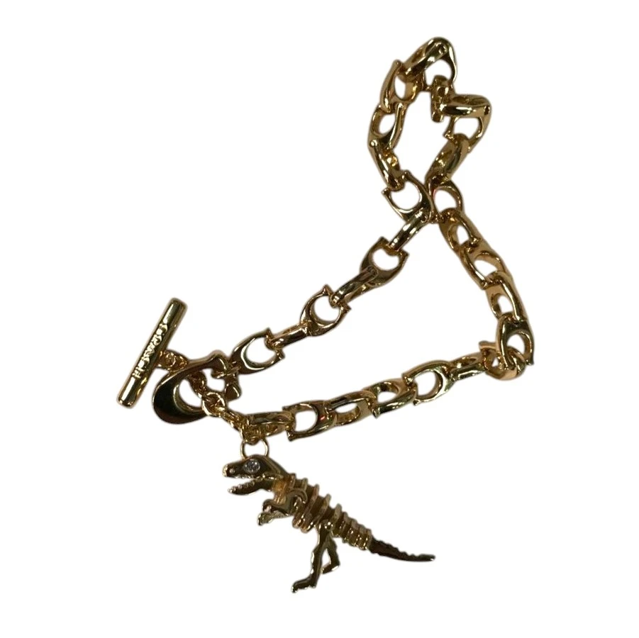PULSERA COACH SKELETAL REXY CON DIJE DE DINOSAURIO – TONO DORADO NUEVO. — imagen 4