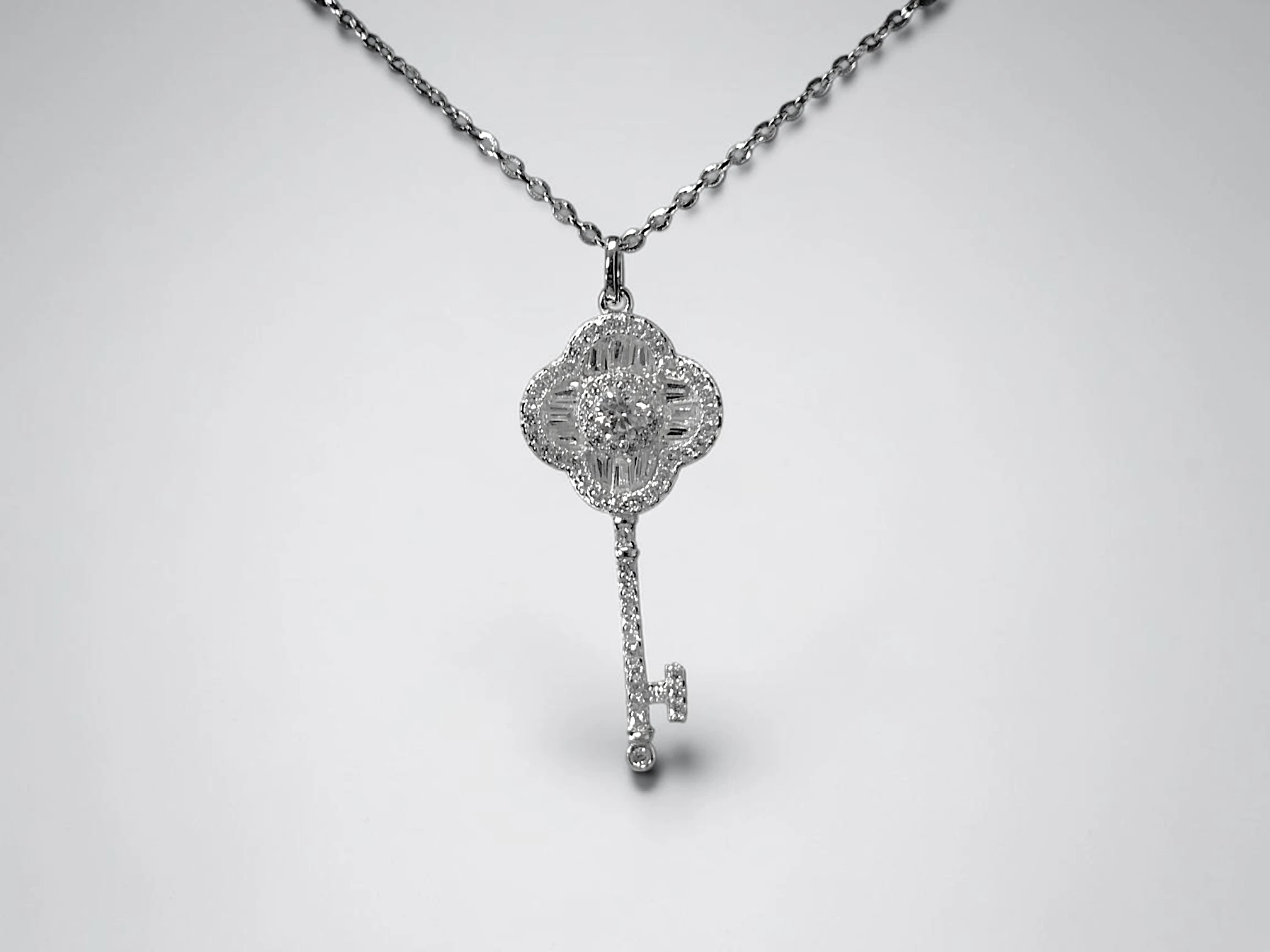 COLLAR CON COLGANTE EN FORMA DE LLAVE Y CABEZA DE TRÉBOL DE CUATRO HOJAS PLATA 925 MOISSANITA. 2.40 gr.