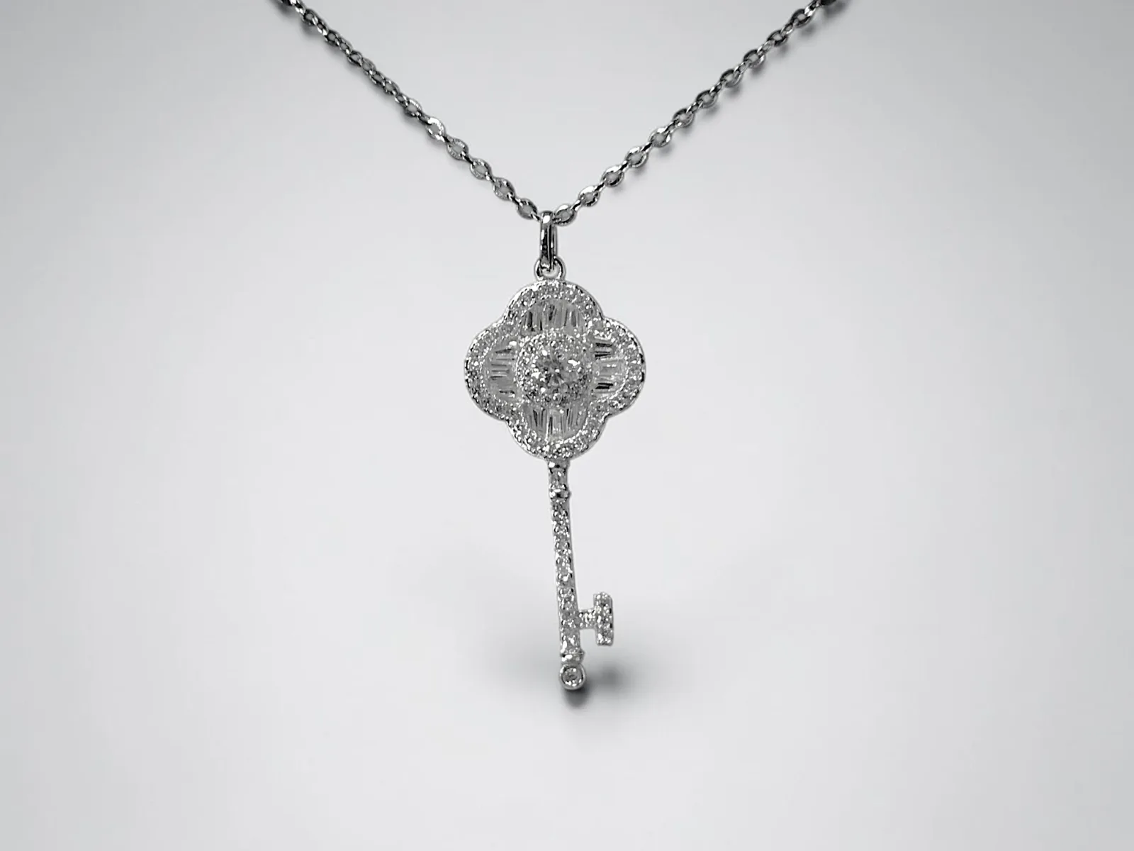 COLLAR CON COLGANTE EN FORMA DE LLAVE Y CABEZA DE TRÉBOL DE CUATRO HOJAS PLATA 925 MOISSANITA. 2.40 gr.